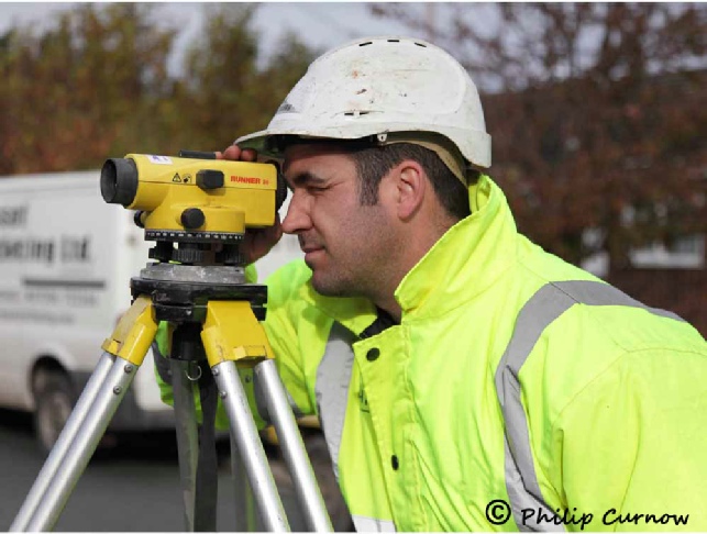 Surveyor at work, preparing to lay new tarmac surface